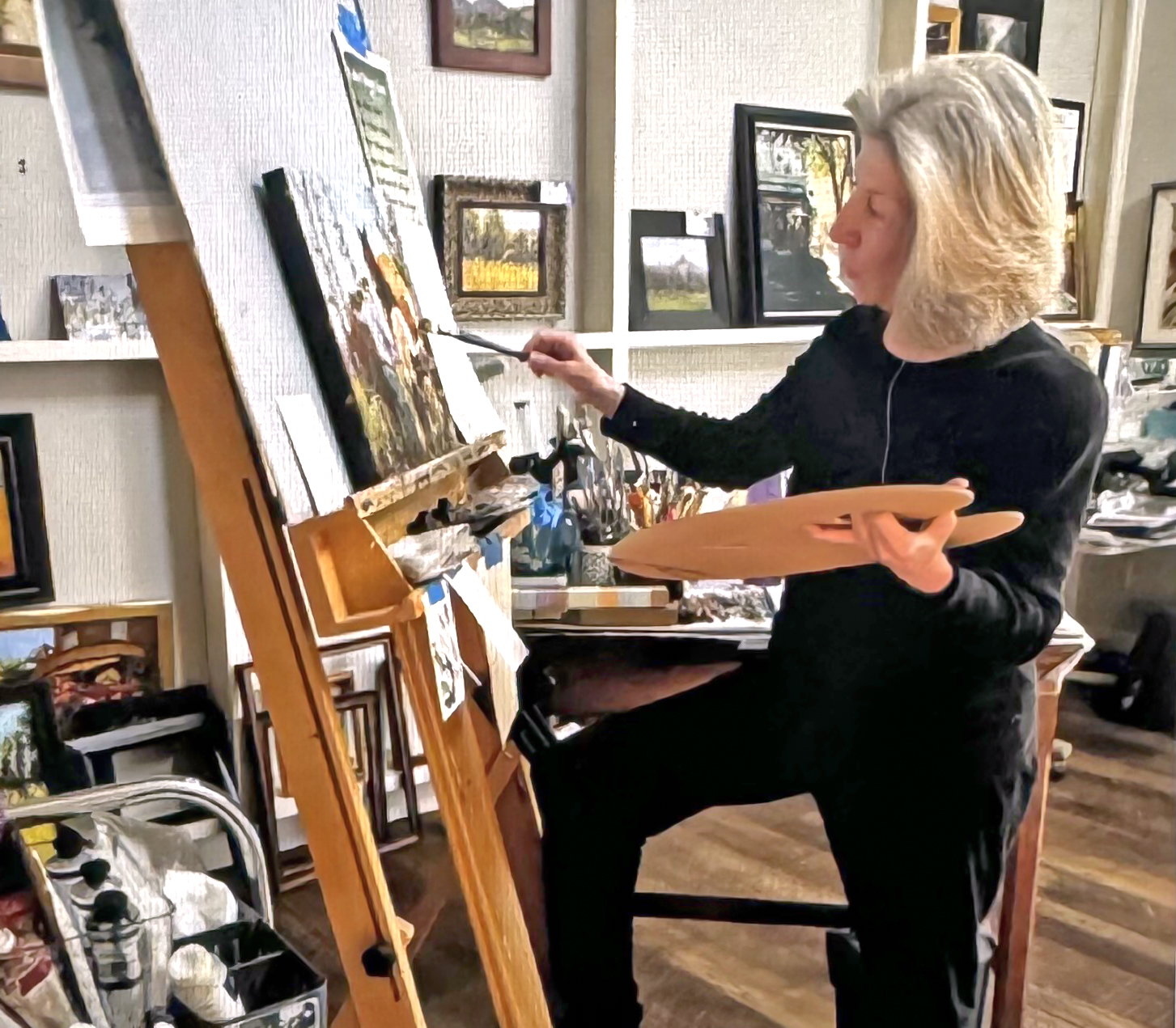 Lynn painting at her easel at home.
