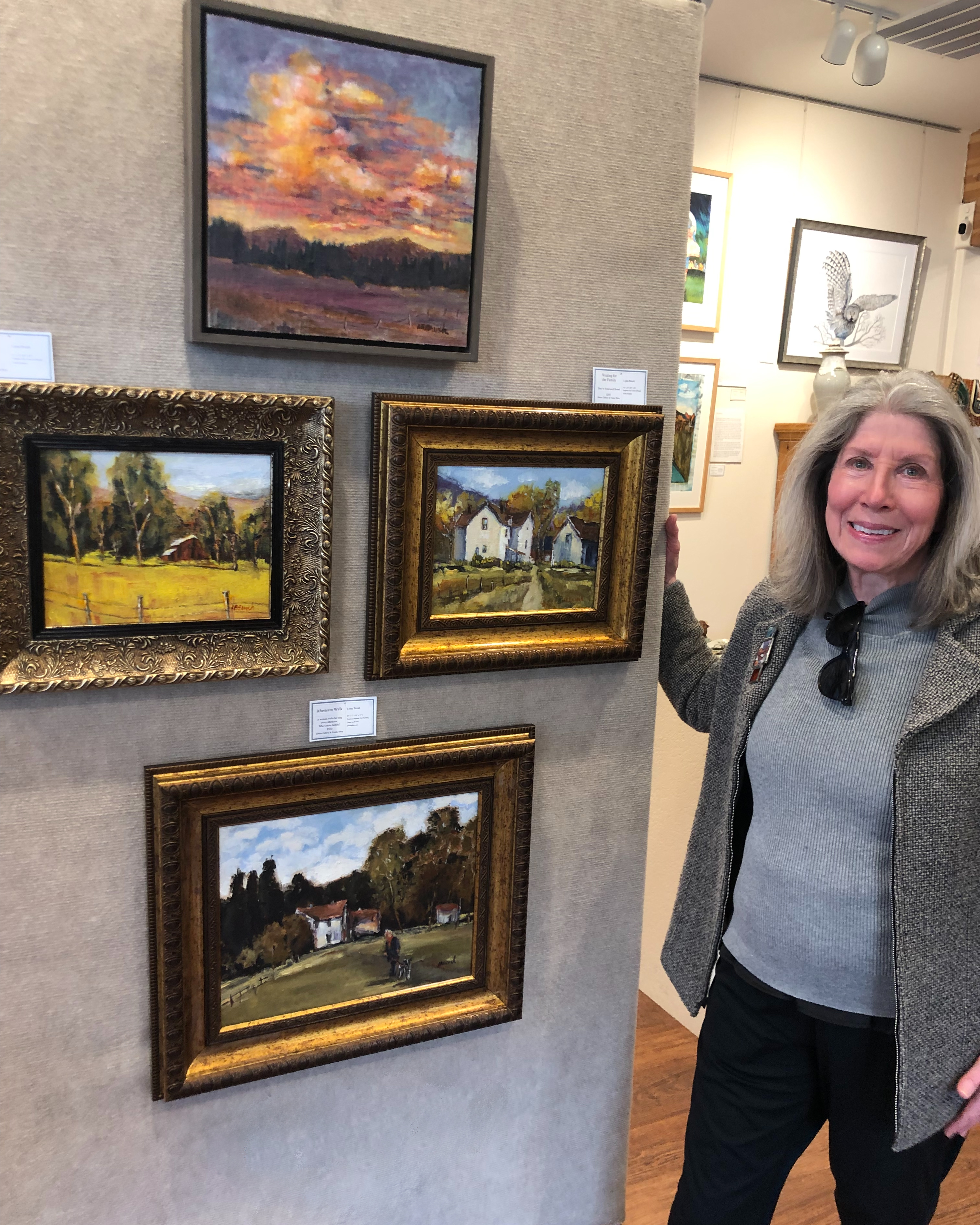 lynn in front of her work at sisters gallery and frame shop
